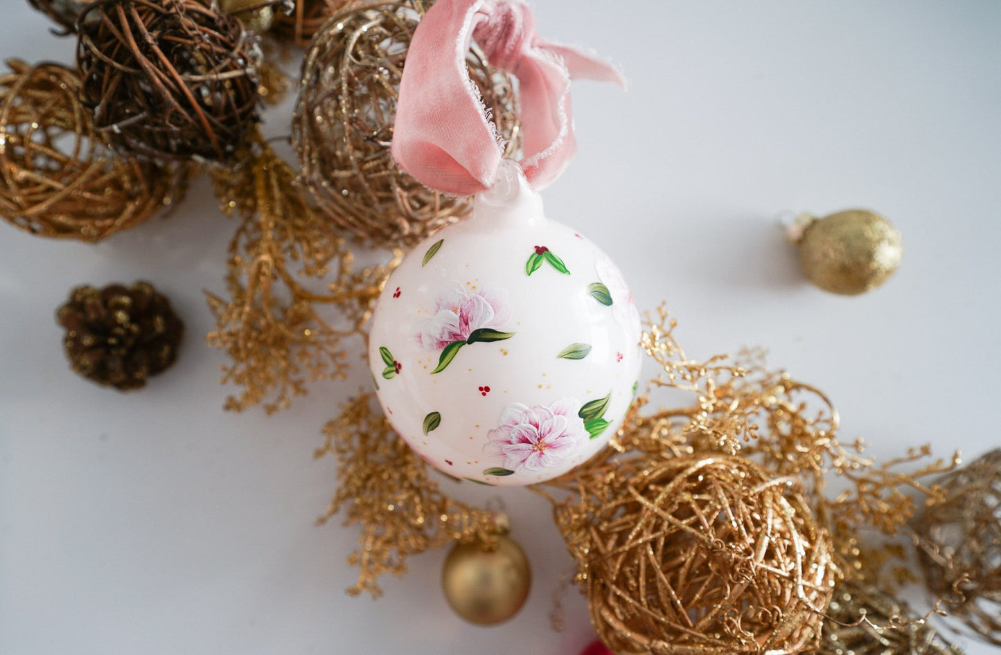 Hand painted florals and mistletoe on blush glass ornament