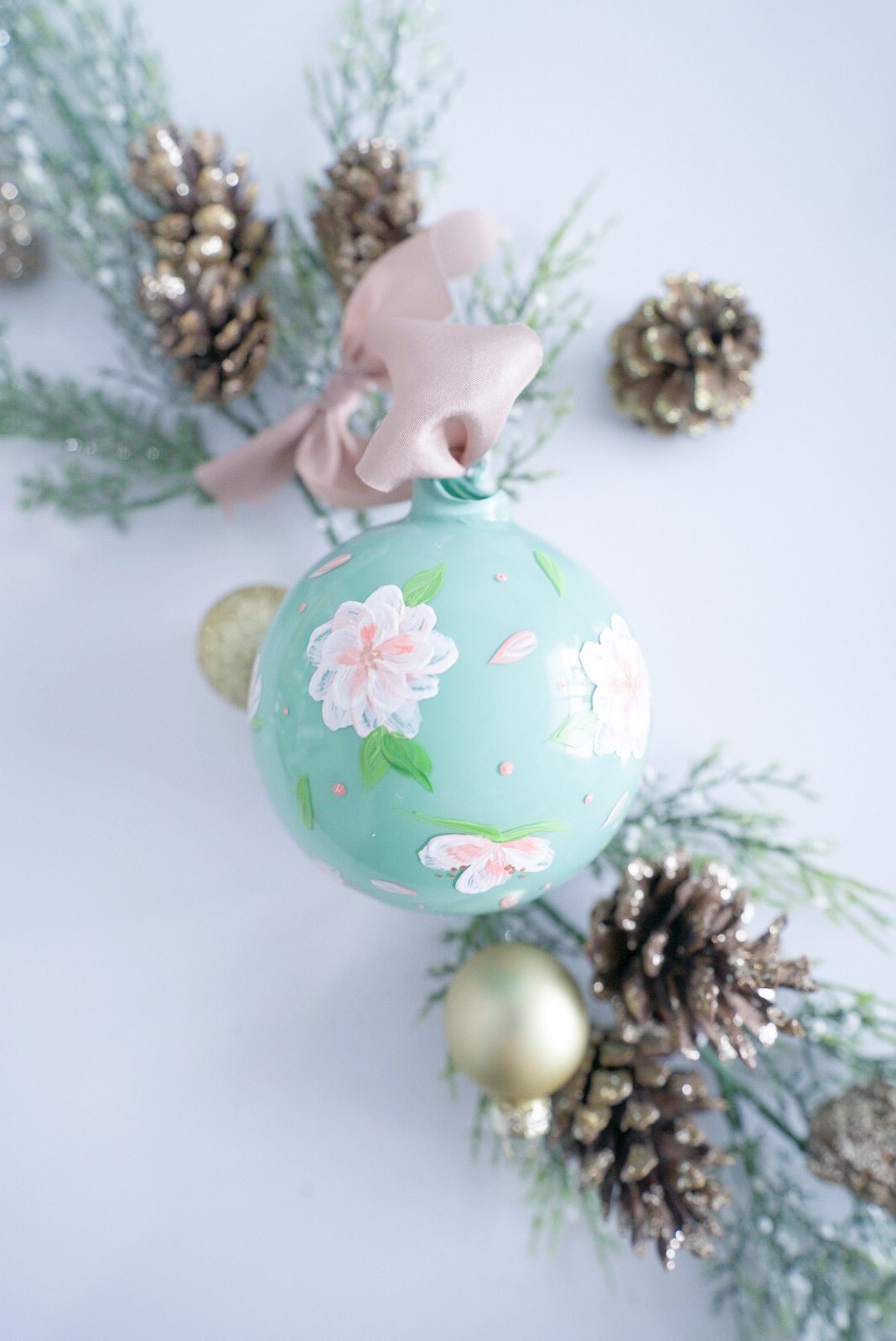Hand painted peach and white florals on blue glass ornament