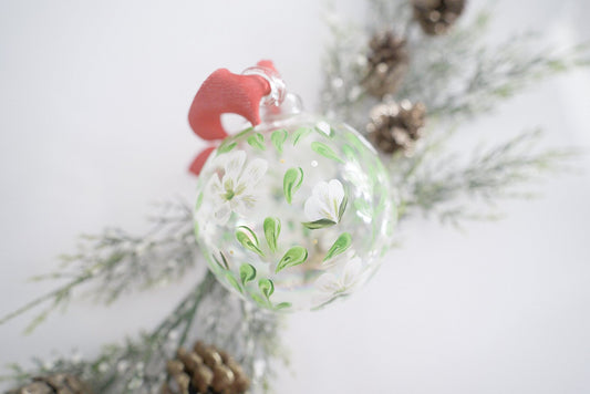 Hand painted magnolias and greenery on clear iridescent glass ornament